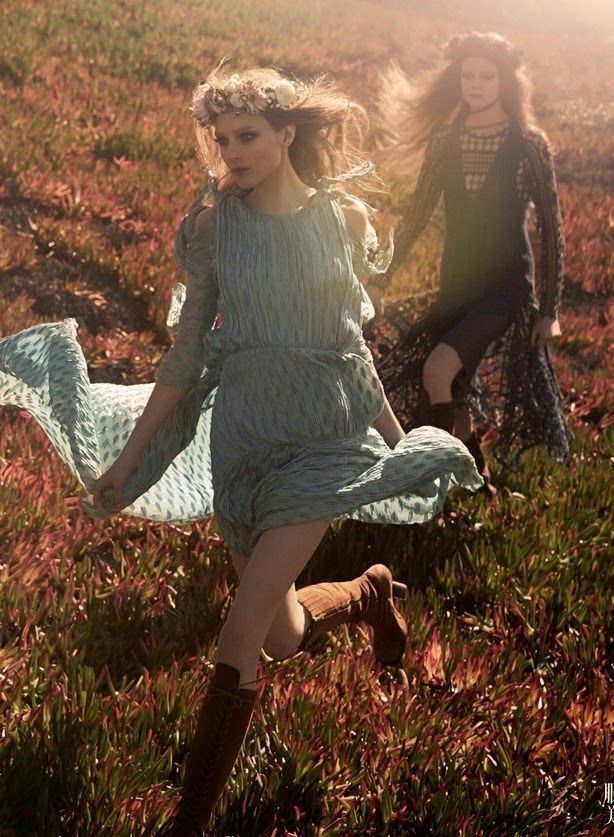 two women in dresses are running through the grass