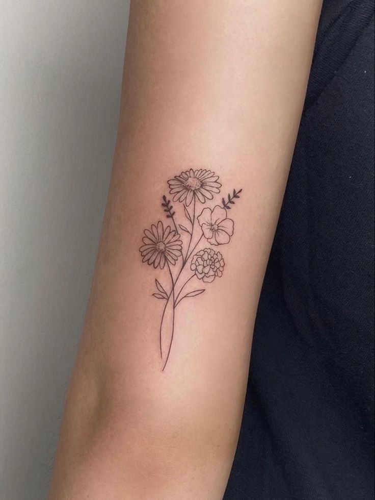 a woman's arm with a flower tattoo on the left side of her arm