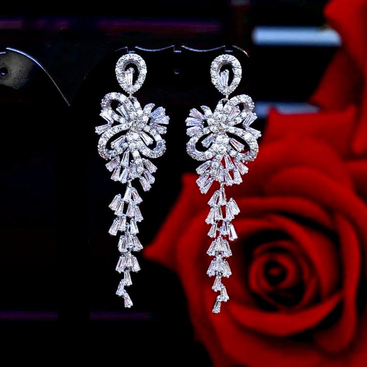 A delightfully unique pair of bridal earrings with an incredible sparkle! Adorned with flawlessly faceted cubic zirconia that capture the light in a dazzling array of sparkles, the earrings are rhodium plated for a bright finish which enhances the intricate detailing and conveys a modern take on old elegance. Length: 60mm (approx. 2.3"). Width: 18mm (approx. 0.7"). Weight: 11g. Available in Silver and Rose Gold finishes. To make your choice select your preferred finish from the dropdown menu to Luxury Festive Cubic Zirconia Chandelier Earrings, Cubic Zirconia Bridal Earrings, Modern Jewellery Design, Contemporary Wardrobe, Silver Wedding Jewelry, Badass Style, Bridal Event, Wedding Accessories Jewelry, Dream Wedding Dresses