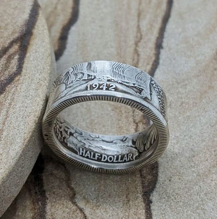 Silver Walking Liberty 1942 Half Dollar Coin Ring Embrace a piece of history with our stunning 1942 Walking Liberty Silver Half Dollar Coin Ring. Meticulously handcrafted, this one-of-a-kind ring showcases the timeless elegance of the iconic Liberty Walking design. Made from an original 90% silver coin, the beautifully preserved features of the coin are prominently displayed on the ring's face. With its rich history and unique craftsmanship, this coin ring is sure to become a cherished heirloom Handmade Vintage Jewelry For Anniversary, Vintage Engraved Round Jewelry, One Of A Kind Antique Jewelry For Anniversary, Collectible Etched Antique Silver Jewelry, Vintage Coin Jewelry For Anniversary, Handmade Antique Silver Engraved Ring, Handmade Antique Silver Vintage Rings, Handmade Vintage Antique Silver Rings, Antique Round Jewelry For Commemoration