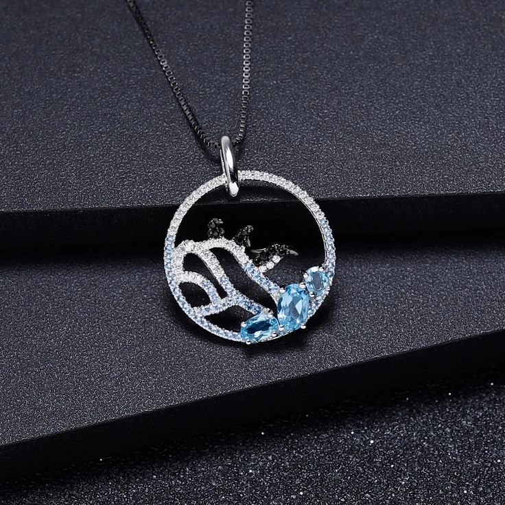 "Dive into a world of Arctic whimsy with our delightful sterling silver and gold necklace, featuring a charming image of three playful penguins frolicking on an iceberg, accented with your choice of blue topaz, nano-sapphire, or rhodolite gemstones. 🐧❄️💎✨ This enchanting piece captures the joy and camaraderie of these beloved creatures in their icy habitat. Meticulously crafted with intricate detailing, the penguins evoke a sense of curiosity and friendship, inviting you to join in their playf Sterling Silver Necklaces With Sapphire Gemstone Accents, Sterling Silver Sapphire Necklaces With Gemstone Accents, Sterling Silver Sapphire Necklace With Gemstone Accents, Sapphire Sterling Silver Necklace With Gemstone Accents, Fine Jewelry White Gold Necklaces With Blue Topaz, Fine Jewelry White Gold Necklace With Blue Topaz, Sapphire Necklaces With Gemstone Accents For Gift, Silver Necklace With Cubic Zirconia And Gemstone Accents, Sapphire Cubic Zirconia Pendant Jewelry