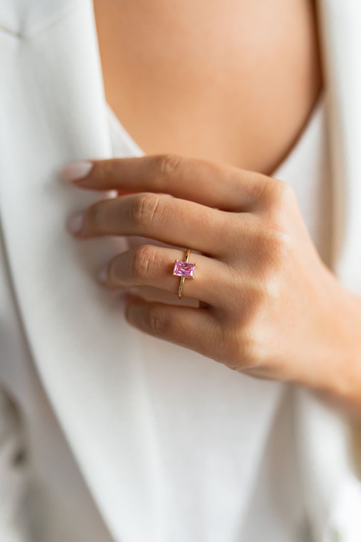 A symbol of eternal love, the humble ring has been about for years, older than any of us and still as important as ever. Liberate yourself from earthly feelings with the Rose Quartz ring and venture into a state of peace and complete happiness, with its spiky tip to usher you into freedom. DETAILS Material: High Quality Solid Sterling Silver 925 Stone: AAA-rated cubic zirconia crystal Stone Size: 7x5 MM Stone Shape: Emerald cut 1.3mm band width Setting Type: Prong Gold Vermeil: The base metal is Emerald Cut Birthstone Stackable Rings For Anniversary, Radiant Cut May Birthstone Ring With Prong Setting, Radiant Cut Ring With Prong Setting For May Birthstone, Princess Cut Birthstone Jewelry For Promise, Princess Cut Birthstone Promise Ring, May Birthstone Diamond Ring For Proposal, May Birthstone Solitaire Ring For Proposal, Promise Ruby Birthstone Ring, Emerald Cut Birthstone Jewelry For Promise