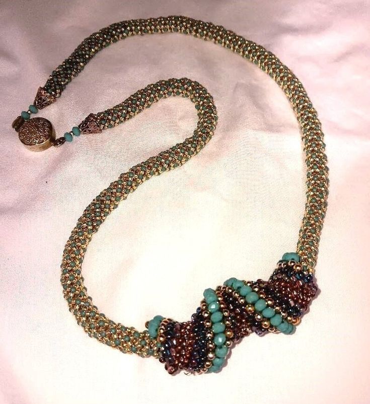 This  beautiful beaded necklace measures 23 inches long.  It has a very pretty gold color closure.  The reverse spiral moves on the chain and has purple gold and turquoise color beads.  This necklace was created by Carol Crawford Spiral Beaded Necklaces As Gifts, Spiral Beaded Necklace As Gift, Spiral Beaded Necklace For Gift, Spiral Beaded Necklace For Gifts, Spiral Colorful Beads For Jewelry Making, Colorful Spiral Beads For Jewelry Making, Beautiful Beaded Necklaces, Spiral Necklace, Beading Jewelery