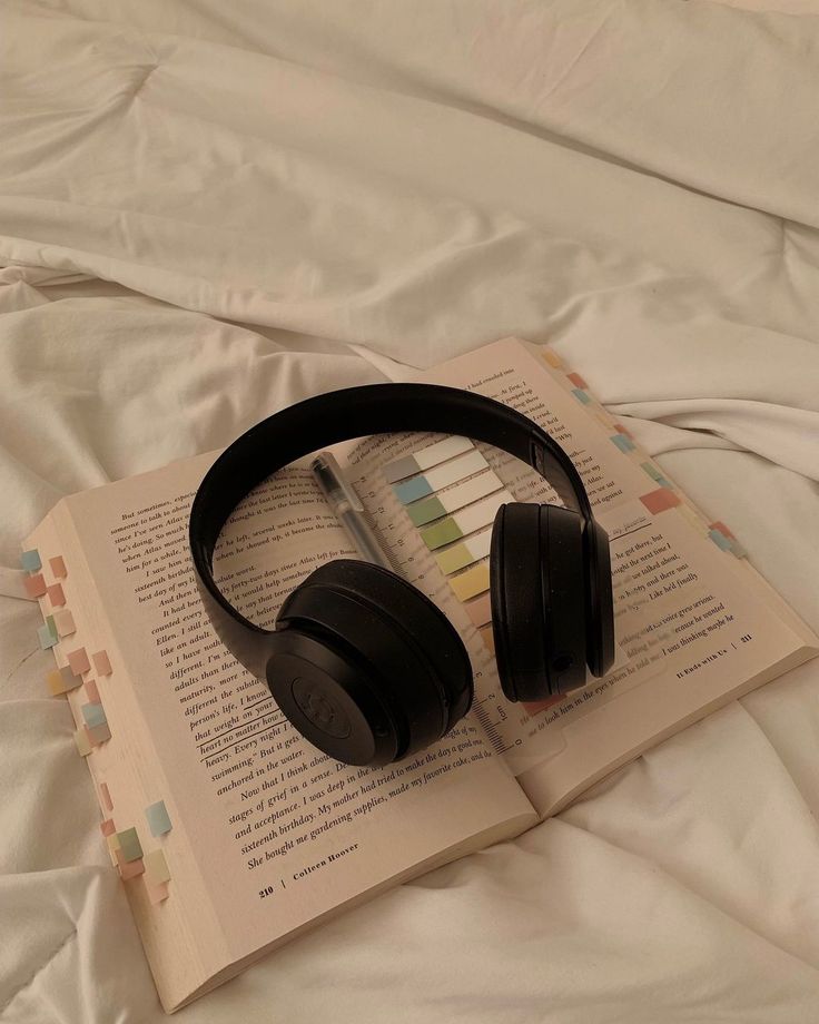 an open book with headphones on top of it