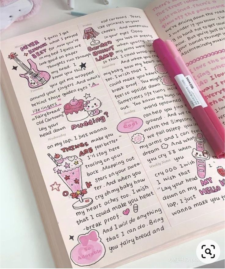 a pink pen sitting on top of an open book