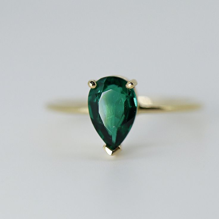 This beautiful Emerald Gold Ring was handmade in Melt'm Jewelry Design Studio in California using 14k solid yellow gold band and 9x7mm pear cut lab grown emerald stone. Emerald is featuring in 14k gold prong setting. DETAILS ABOUT THE RING, MATERIAL AND STONES Ring Band: 14K solid gold Ring Band size: 1.2 mm thick Gemstone: Lab grown Emerald Emerald size: 9mm x 7mm pear cut It is a great birthday gift for your special ones whose birthday are in May, since Emerald is May birthstone. This solid go Elegant 14k Gold Teardrop Emerald Ring, Elegant Teardrop Emerald Ring In 14k Gold, Pear-shaped Emerald Ring In 14k Gold, Classic Pear-shaped Emerald Ring Gift, Classic Teardrop Emerald Ring As Gift, Classic Green Teardrop Emerald Ring, Pear-shaped Emerald Ring For Promise, Pear-shaped Emerald Solitaire Jewelry, Classic Pear-shaped Emerald Ring