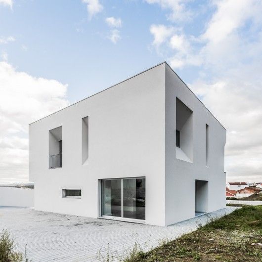 a large white building sitting on top of a grass covered field