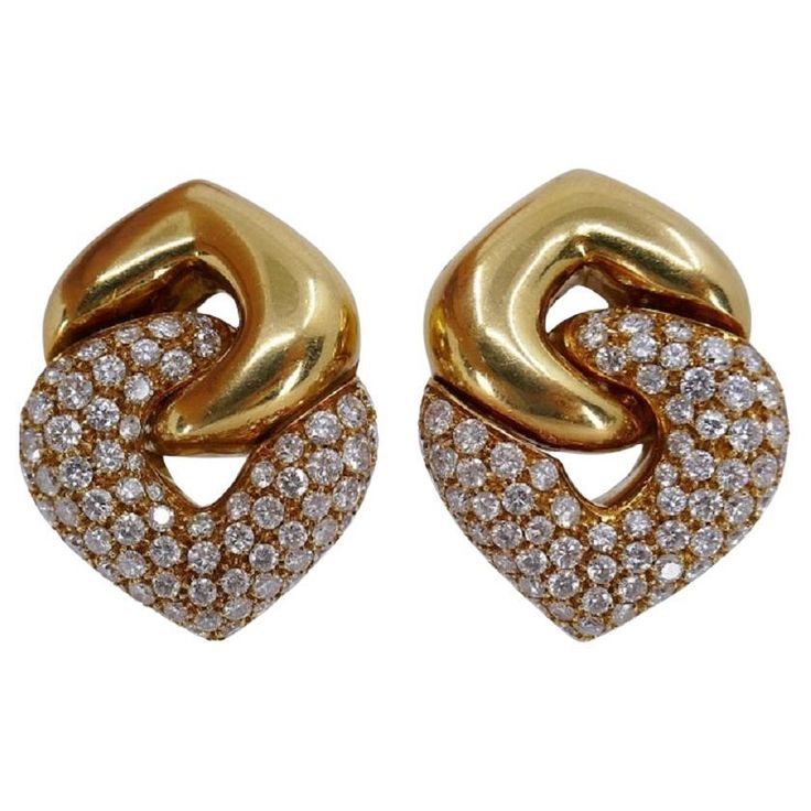 A pair of the classic Bulgari Doppio Cuore earrings in yellow gold, featuring diamonds. The earrings are designed as two interlocked hearts: a gold reversed heart holds a diamond one. This pair is the largest in the wide range of the collection's sizes. The heart design is one of the widely using element in Bulgari jewelry making. It reflects the brand's ability to infuse romance and passion into a piece. Bulgari's heart design is not only visually captivating but also emotionally resonant. Whet Luxury Heart-shaped Diamond Earrings, Formal Heart-shaped Yellow Gold Diamond Earrings, Luxury Gold Heart Earrings For Formal Occasions, Gold Luxury Heart Earrings For Formal Occasions, Gold Heart Earrings With Brilliant Cut For Formal Occasions, Gold Brilliant Cut Heart Earrings For Formal Occasions, Elegant Yellow Gold Heart Earrings With Brilliant Cut, Elegant Clip-on Heart Earrings For Anniversary, Luxury Heart Earrings With Diamond Accents