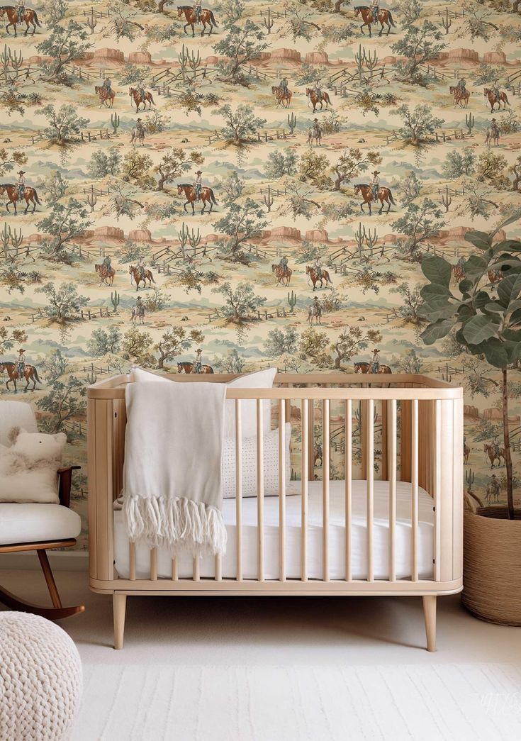 a baby's crib in front of a wallpaper with horses on it