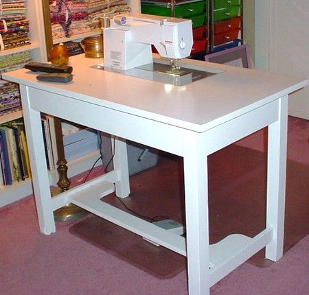 a sewing machine sitting on top of a white table next to a shelf filled with books