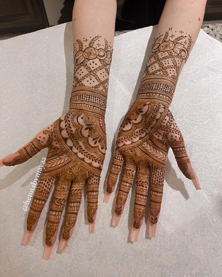 two hands with henna designs on them