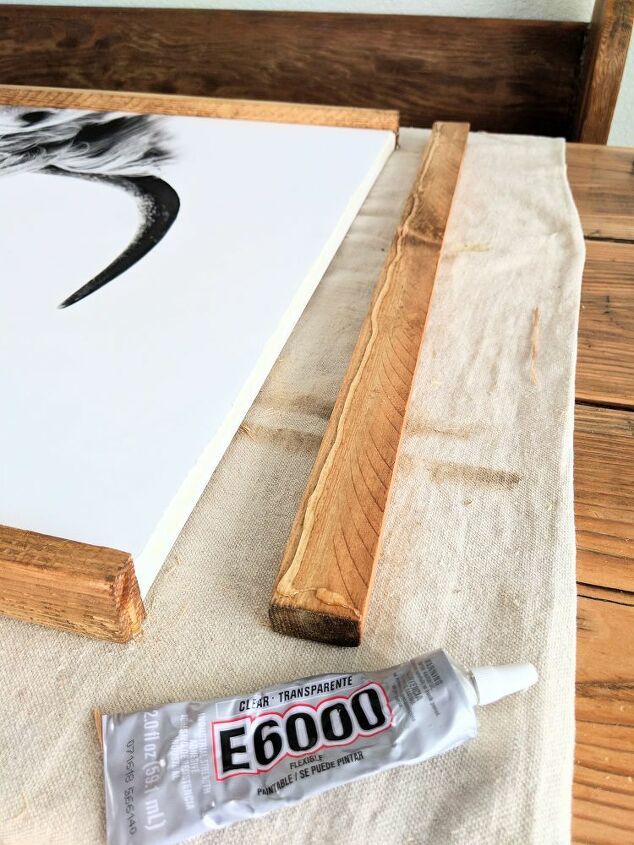 a piece of wood sitting on top of a table next to a tube of glue