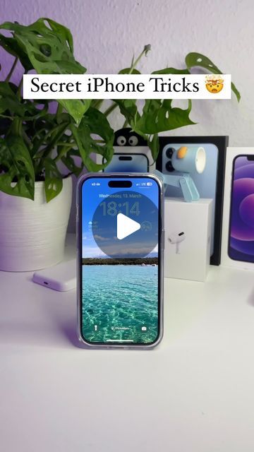 two iphones sitting next to each other on top of a white table in front of a potted plant