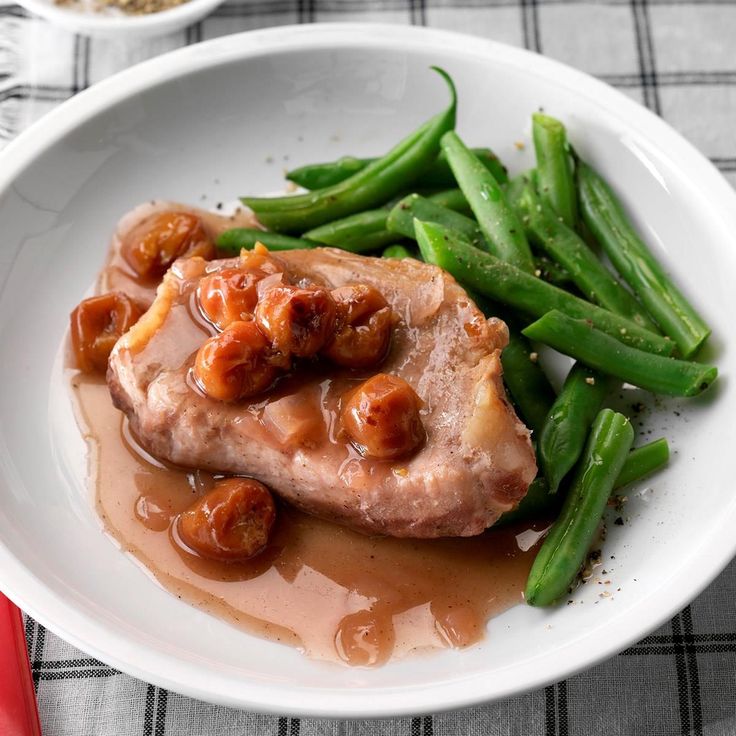 a white plate topped with meat and green beans