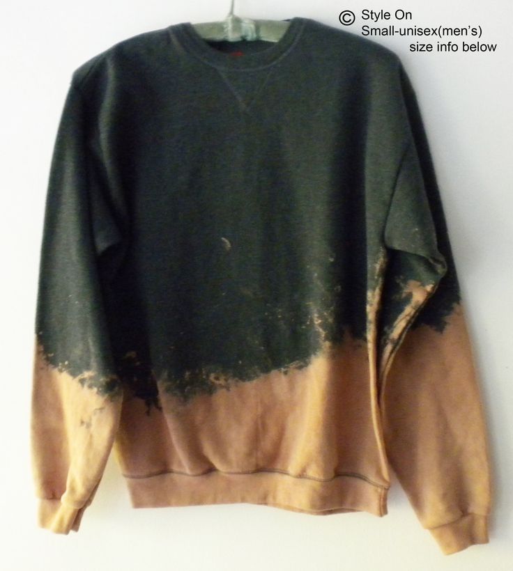 a green and brown sweatshirt hanging on a white wall