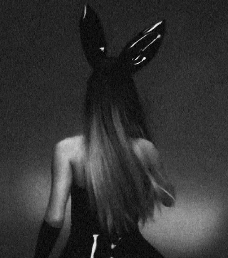 a woman with long hair and bunny ears on her head is standing in the dark