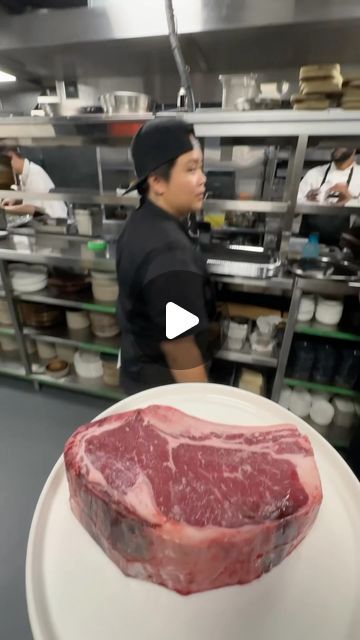 a man standing in front of a large piece of meat