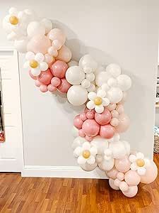 balloons are arranged in the shape of a letter on a wooden floor next to a white wall