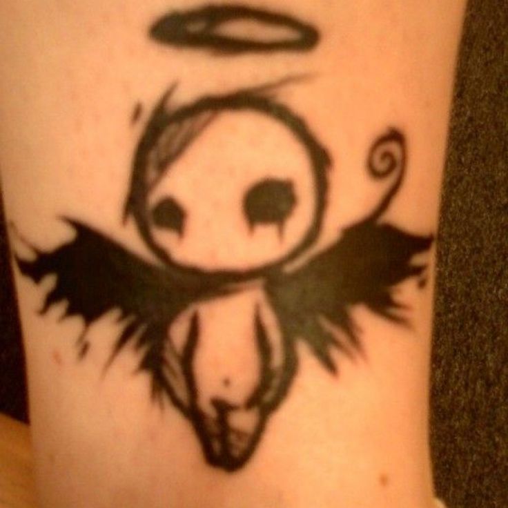 a tattoo on the leg of a person with an angel and demon symbol above it