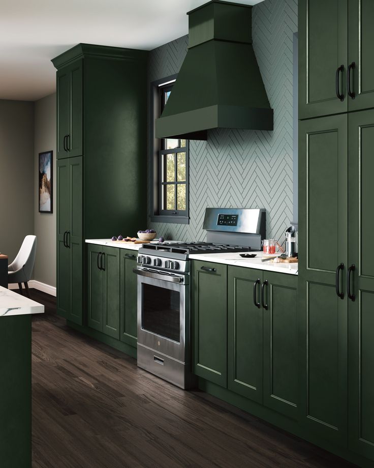 a kitchen with green cabinets and stainless steel stove top oven in the center of the room