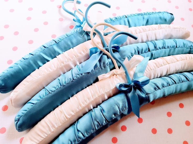 four blue and white pillows tied together on a polka dot table cloth with ribbons attached to them