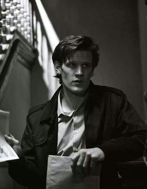 black and white photograph of a young man holding a piece of paper in his hand