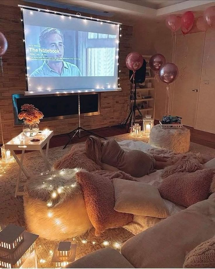 a living room filled with lots of furniture and balloons in the air, while someone is watching tv