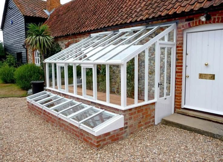 a green house sitting next to a brick building with the words, considerations before building lean to greenhouse