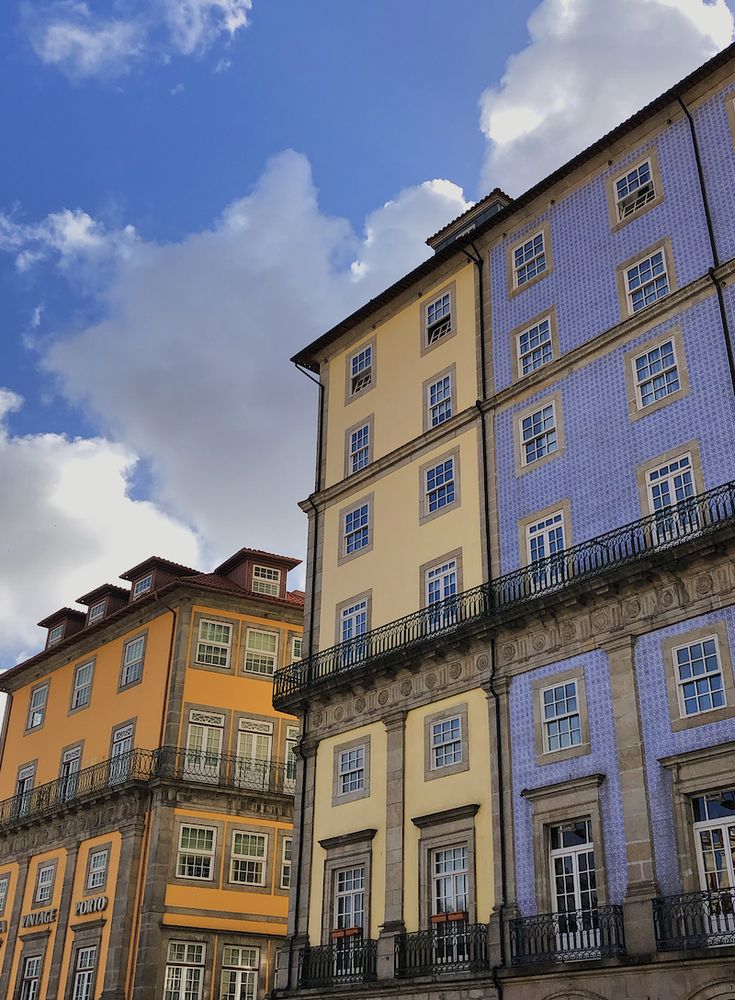 some very tall buildings with balconies on the top and bottom floors in different colors