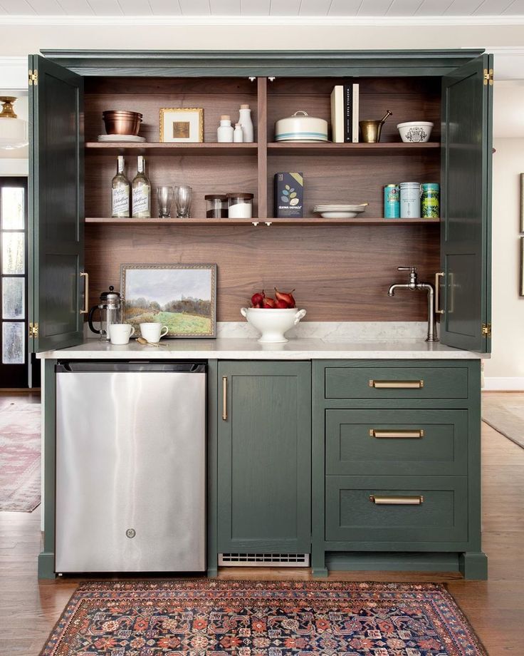 a kitchen with green cabinets and stainless steel appliances, including a dishwasher that has the words mini kitchen above it