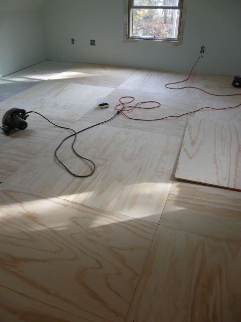 an unfinished room with hard wood floors and electrical cords