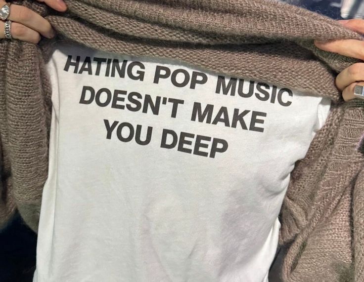 a woman holding up a t - shirt that says hating pop music doesn't make you deep