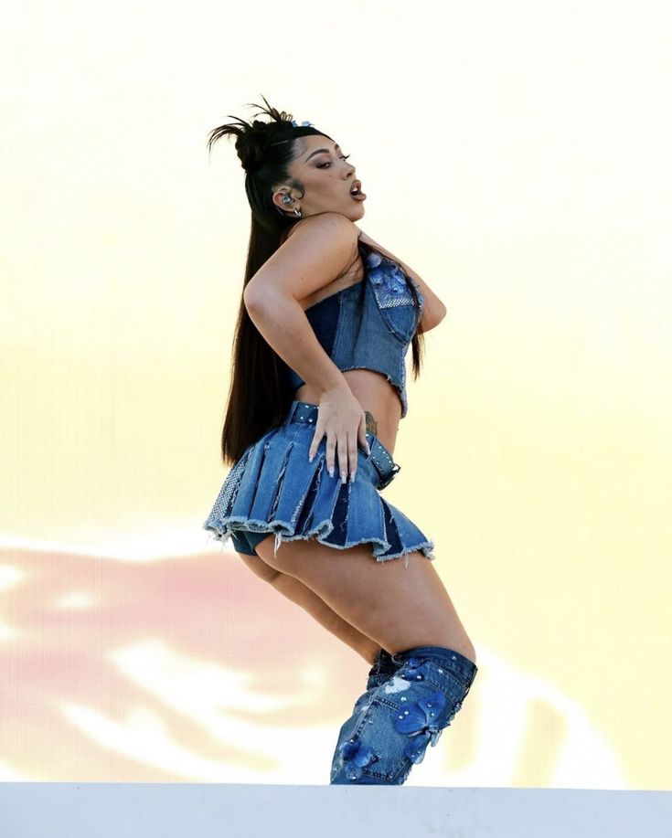 a woman in blue dress and boots on stage