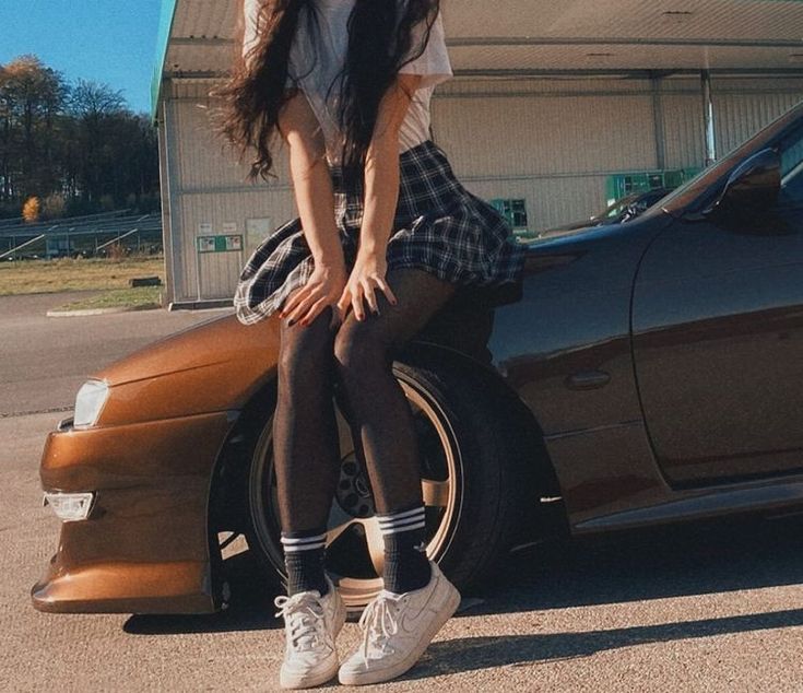 a woman sitting on the hood of a car