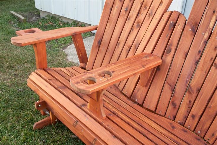 a wooden lawn chair sitting in the grass