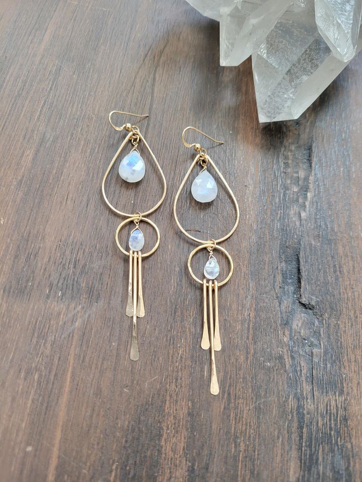 Gorgeous and fun Moonstone Goddess Earrings. Moonstone is said to be a stone of new beginnings. A stone of strength and inner growth. It is also said to be linked to to the divine feminine. It is believed to connect with the moon's energy, bringing balance, calm, abundance, and intuition to the person wearing it. I bet you will also feel your inner goddess when wearing them! Each piece is hammered for texture and shape. The top teardrop hoop and the bottom circle linked to it are not fixed so they will move around creating fun movement. The length is just a little over 3 1/4 in. Each piece is handmade and may vary slightly as well as the stones as they are natural. some will have more blue 'flash" than others. Thank you! Nickel-free Teardrop Spiritual Jewelry, Spiritual Teardrop Nickel-free Jewelry, Celestial Dangle Earrings For Everyday, Celestial Gemstone Brass Jewelry, Celestial Teardrop Earrings Gift, Celestial Brass Jewelry With Gemstones, Celestial Teardrop Earrings For Gift, Celestial Style Dangle Earrings For Everyday, Celestial Brass Gemstone Jewelry