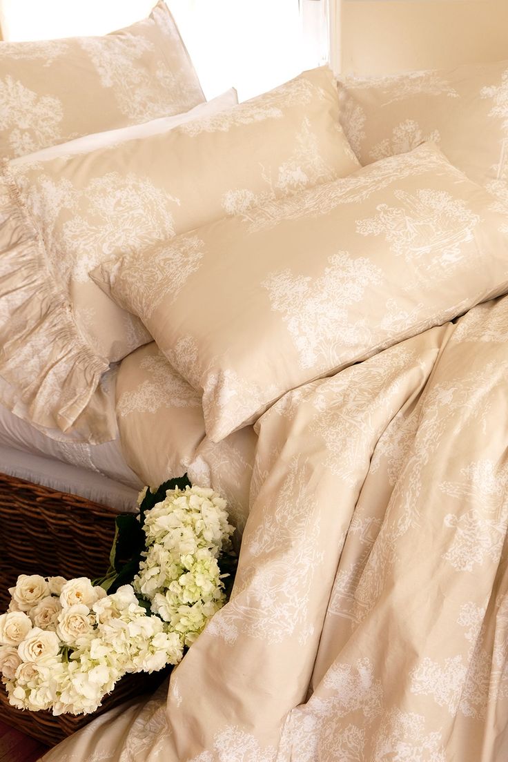 a bed with white flowers and sheets on it