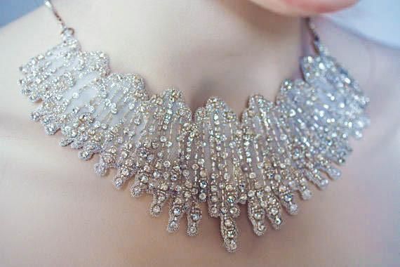 a close up of a woman's neck wearing a silver necklace with crystal beads