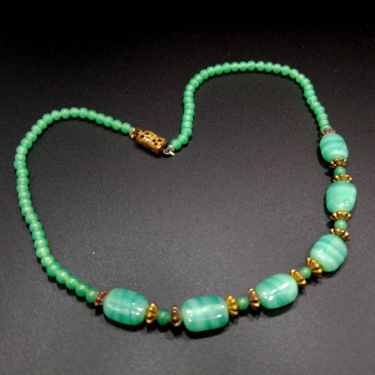 *Description: This necklace is made from faux jade green glass beads that have small air bubbles in them from the 1930s or before. They would be perfect to restring as they are most likely antique beads and the metal plated findings did not hold up as well as the glass beads. Unchecked from a gem tester, you would believe these to be jade but they are indeed glass. Looking closely with a loop, you can see the air bubbles within many of the glass beads. The necklace is 15 inches in length. This w Antique Green Beaded Necklace As Gift, Vintage Green Beaded Necklaces With Round Beads, Green Vintage Jewelry With Gemstone Beads, Vintage Green Beads For Jewelry Making, Antique Green Beaded Necklace For Gift, Retro Green Beaded Necklace For Gift, Antique Green Beaded Jewelry, Green Jade Necklaces With Spacer Beads, Vintage Green Beaded Necklace With Round Beads