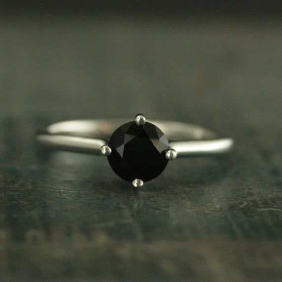 a black diamond ring sitting on top of a wooden table