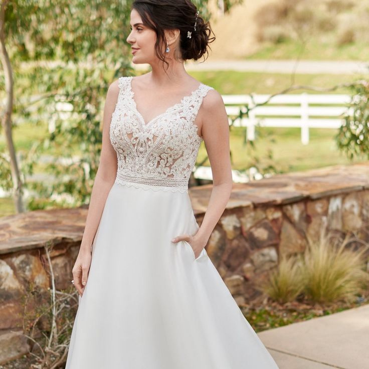 a woman in a white wedding dress standing outside