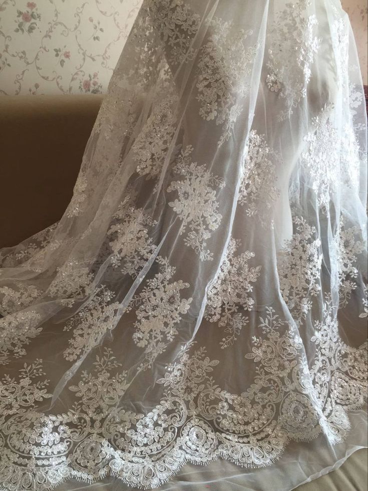 the back of a wedding dress with white lace on it