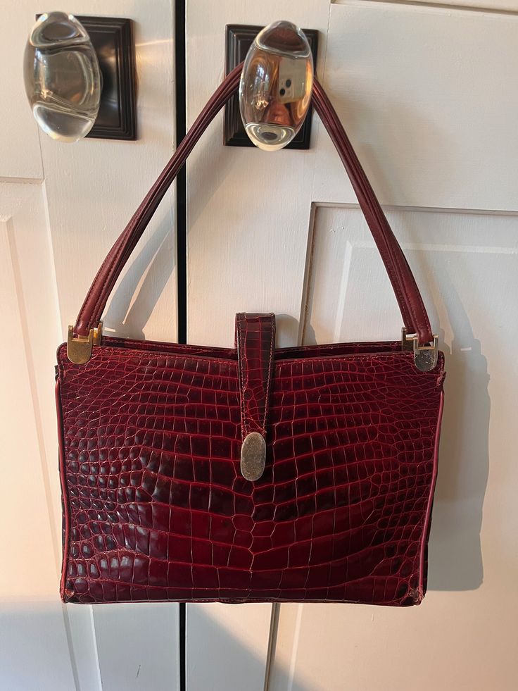 Stunning large alligator handbag. The color must be seen to be appreciated, it's a deep aubergine/wine/oxblood. Skins are in perfect condition. Some slight scratches on the hardware, barely noticeable. Zipper compartments inside. Snaps shut, also has a foldover strap that snaps. Classic Crocodile Pattern Shoulder Bag For Formal Occasions, Classic Formal Shoulder Bag With Crocodile Pattern, Formal Burgundy Shoulder Bag With Double Handle, Formal Burgundy Double Handle Shoulder Bag, Formal Burgundy Double Handle Satchel, Formal Burgundy Satchel With Handle Drop, Alligator Handbags, Top Handle Bags, Wine Color