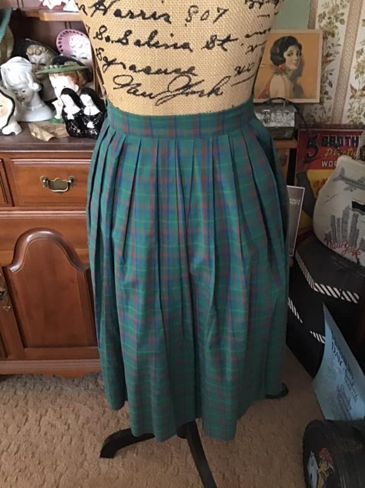 "Vintage 1970's plaid Cotton blend skirt. The main color is green with subtle Yellow, Blueish Purple Bittersweet Orange. Has a one button closure on the left side. The skirt is to small for my dressform, so it is clipped on the button side. *MORE INFORMATION BELOW* CONDITION: I note on the left side by the button, the skirt opening could use a few stitches to make the opening smaller (SEE PIX). There is supposed to be an opening in that area to be able to get the skirt on. Only closes with the o Classic Green Pleated Skirt, Vintage Plaid Pleated Skirt, Vintage Plaid Full Skirt, Retro Green Pleated Bottoms, Retro Green Pleated Skirt, Vintage Green Full Skirt Bottoms, Vintage Green Full Skirt, Blueish Purple, Vintage Clothing Boutique