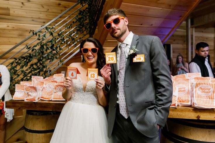 a bride and groom pose for a photo in front of some wine barrels at their wedding