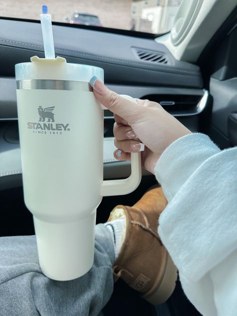 a person holding a cup in their hand while sitting in the driver's seat