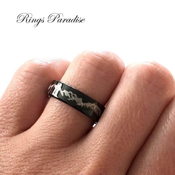 a person's hand with a black ring on it and the words rings paradise written in white lettering