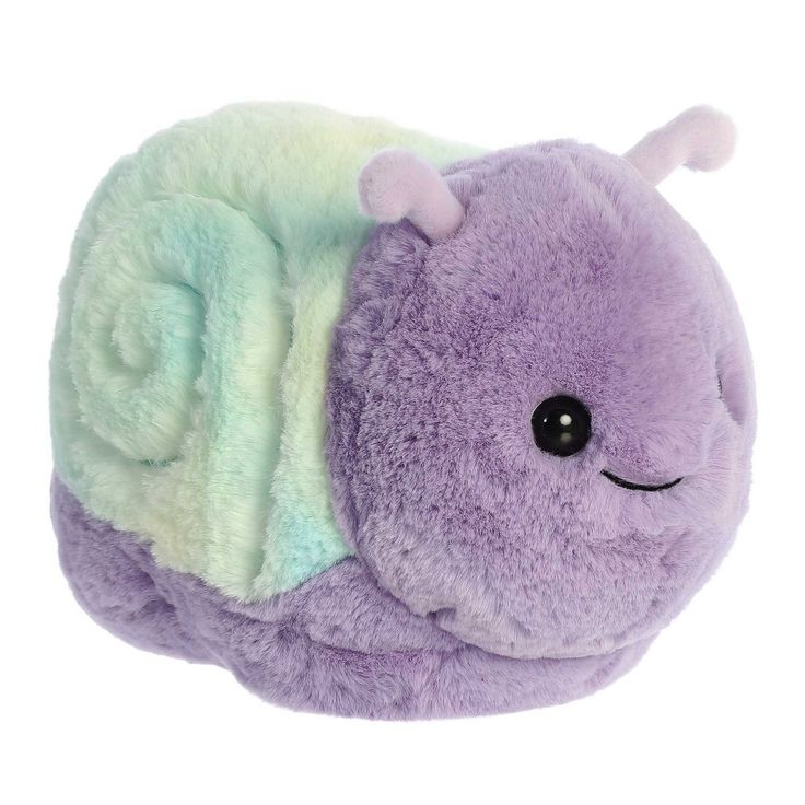 a purple and green stuffed animal laying on top of it's side with its eyes closed