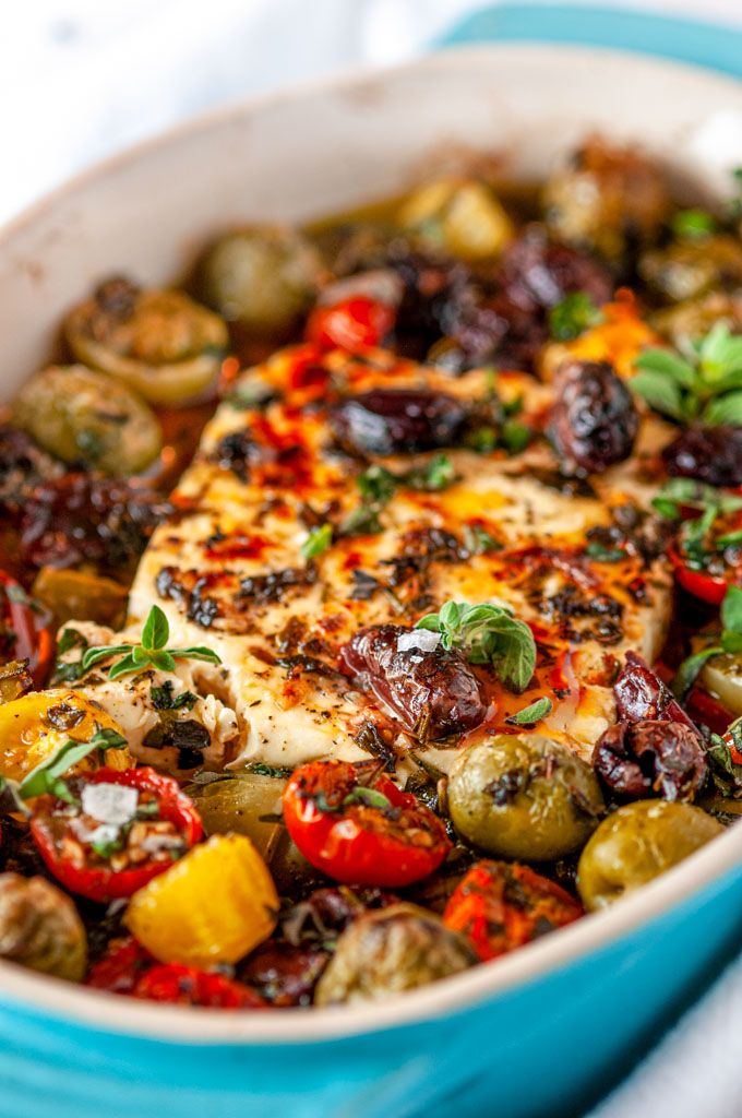 a casserole dish with chicken, olives, peppers and potatoes in it