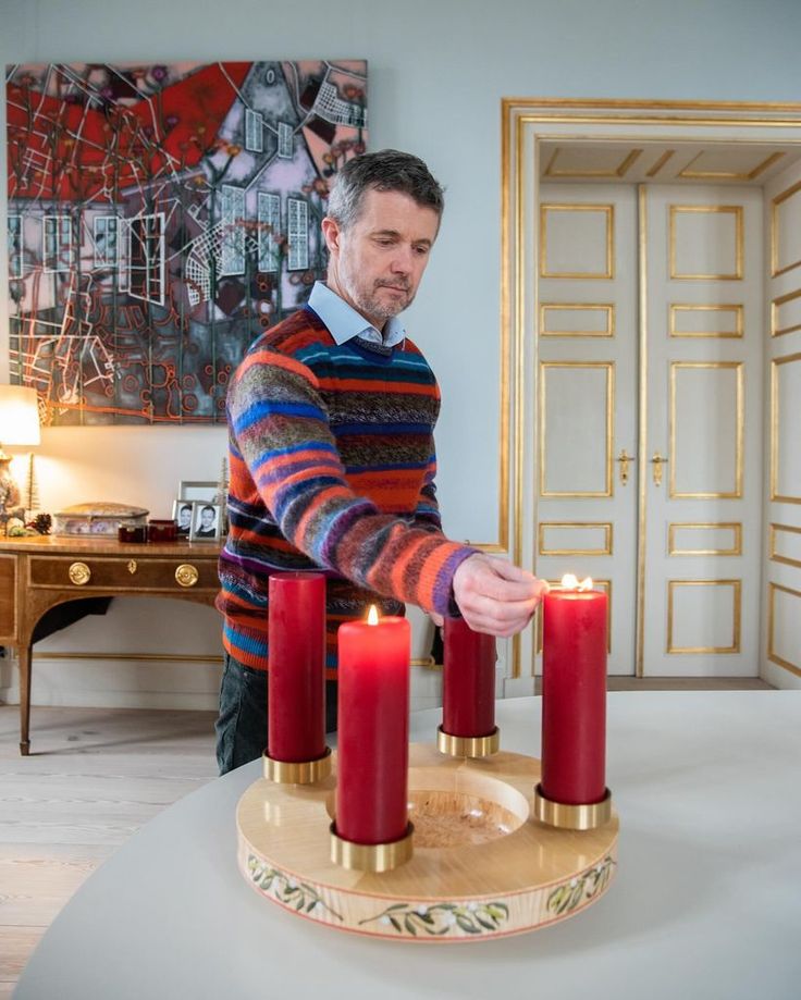 a man lighting candles on a table in his living room